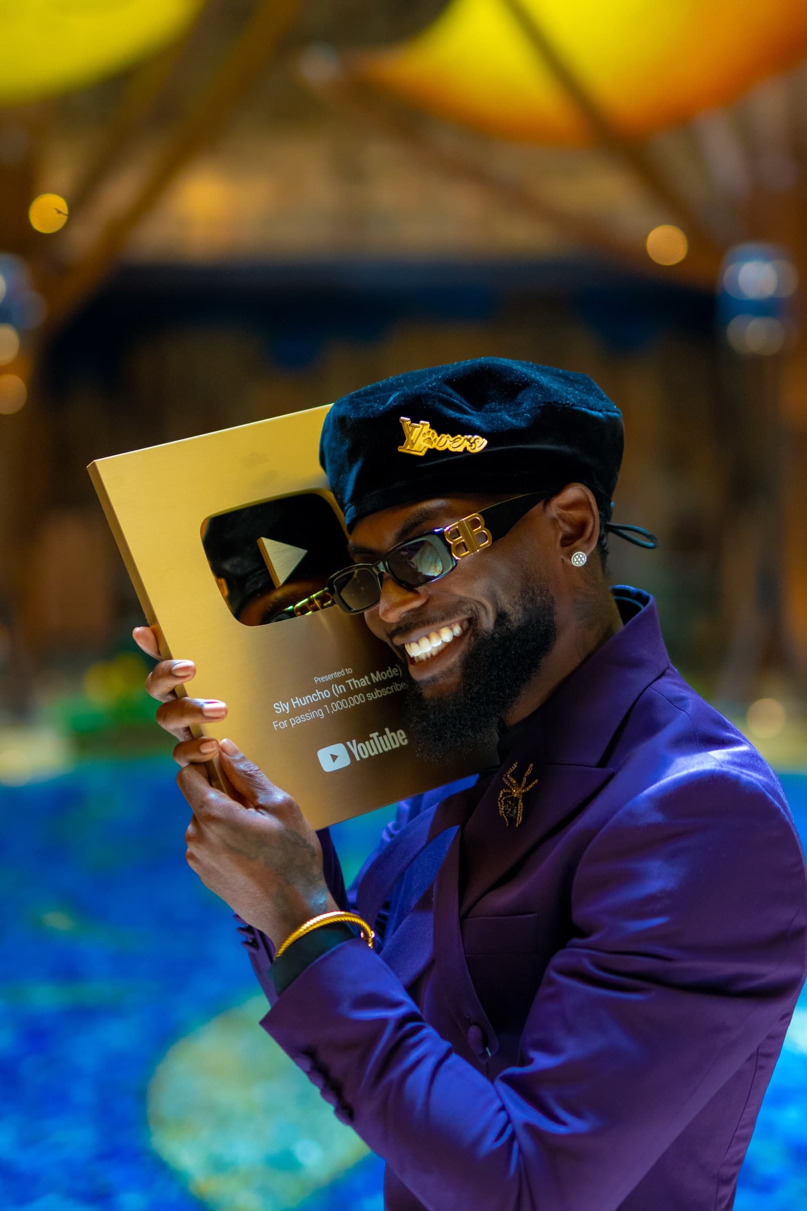 Sly Huncho smiling while holding a YouTube Gold Creator Award