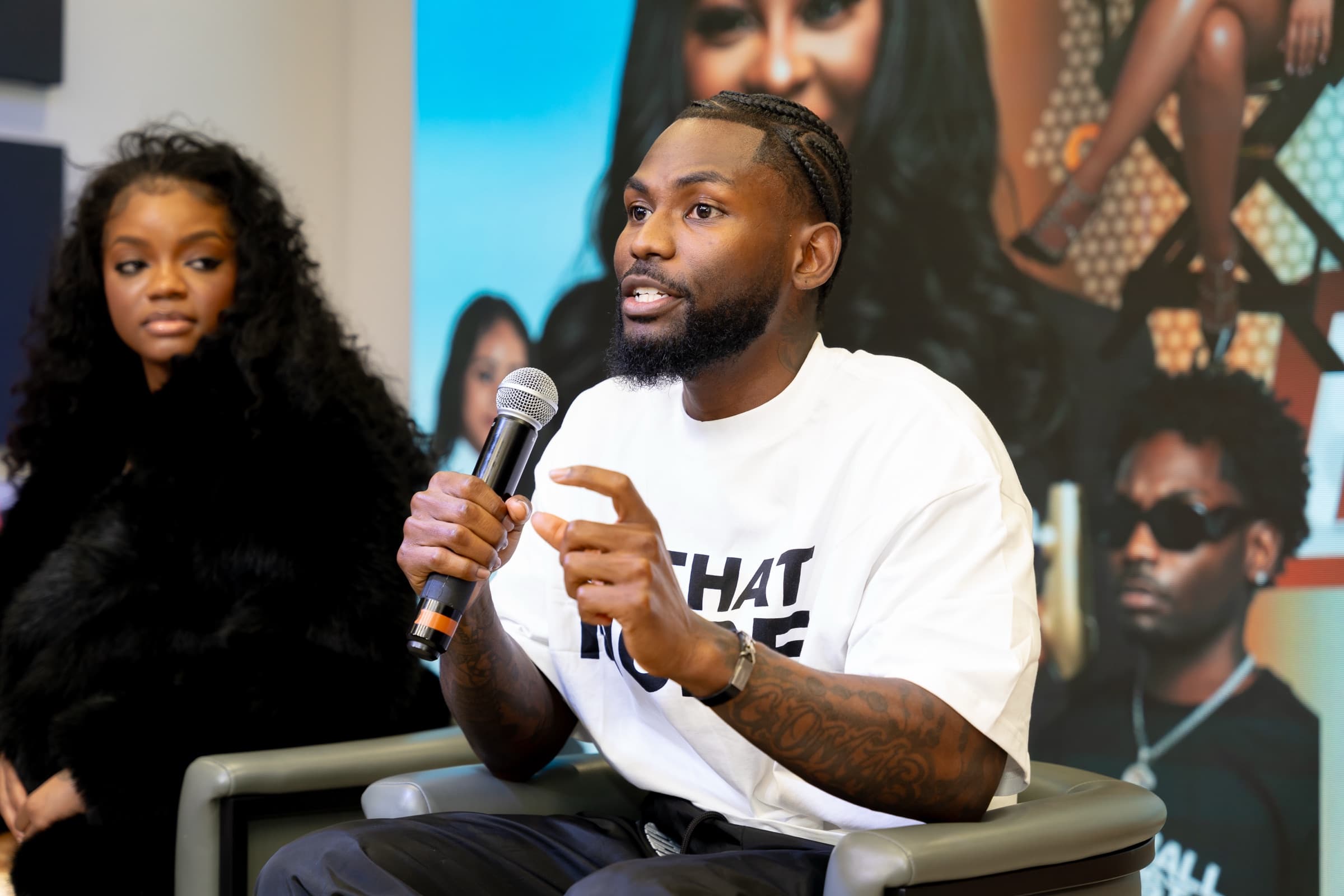 Sly Huncho speaking on a panel with a microphone